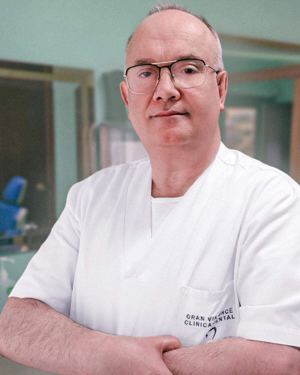 Fotografía de retrato de un dentista con décadas de experiencia mirando hacia la cámara