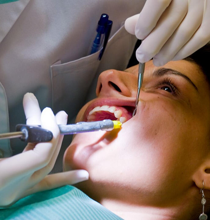 Plano del rostro de una paciente de odontología en el momento de recibir una inyección de anestésico local